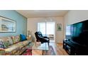 Comfortable living room featuring a sofa, recliner, television and sliding glass doors to the exterior at 3534 Lake Bayshore Dr # 118, Bradenton, FL 34205