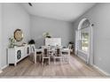 Bright dining room featuring wood floors, a modern white table set, a large window, and light gray paint at 3703 Treeline Dr, Valrico, FL 33596