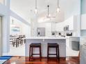 Bright, airy kitchen with white cabinets, a center island, and a view into the adjacent dining area at 382 Florian Way, Spring Hill, FL 34609