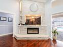 Living room featuring a modern fireplace, built-in shelves, and wood floors at 382 Florian Way, Spring Hill, FL 34609