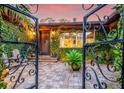 Inviting front entrance with a wrought-iron gate, ivy-covered exterior, and a quaint, tiled entryway to 