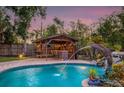 Backyard pool and tiki bar with dolphin water feature, offering a relaxing and entertaining outdoor space at 4301 S Lockwood Ridge Rd, Sarasota, FL 34231