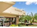 Well-maintained building exterior featuring tropical landscaping and signage at 4550 Cove Cir # 1003, St Petersburg, FL 33708