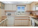 Bright kitchen with white cabinets, tile backsplash, and a window offering a view at 4550 Cove Cir # 1003, St Petersburg, FL 33708