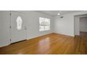 Spacious living room with hardwood floors, a front door, and a large bright window at 5642 9Th N Ave, St Petersburg, FL 33710