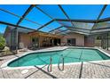 A luxurious screened-in pool area with a brick patio, lounge chairs, and a sparkling blue pool, ideal for outdoor enjoyment at 6101 Willow Oak Cir, Bradenton, FL 34209