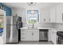 Bright eat-in kitchen features white cabinets, stainless steel appliances and tile flooring at 6188 80Th N St # 101, St Petersburg, FL 33709