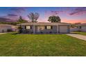 Charming single-story home with a well-maintained lawn and inviting curb appeal at sunset at 6490 22Nd S St, St Petersburg, FL 33712