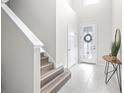 Bright foyer with tile flooring, a decorative mirror, and a staircase leading to the upper level at 6563 Ryestone Way, Wesley Chapel, FL 33545