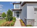 Inviting entryway featuring a blue door, a decorative wreath, stone accents, and fresh landscaping at 6563 Ryestone Way, Wesley Chapel, FL 33545