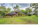 Charming home with beautiful lawn, palm trees and mature landscaping at 707 Warren Rd, Lutz, FL 33548