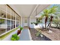 Inviting front porch featuring hanging plants, a palm tree, and a walkway leading to the main entrance at 829 Riverside Dr, Tarpon Springs, FL 34689