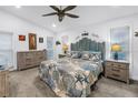 Bright bedroom with a unique blue headboard, beachy decor, and ample natural light from the two windows at 9611 107Th N Ave, Largo, FL 33773