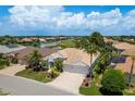 Beautiful home with water views, lush landscaping, a barrel tile roof, and brick driveway at 987 Chickadee Dr, Venice, FL 34285
