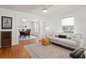 Bright living room showcasing hardwood floors, a comfortable sofa, and seamless flow to dining area at 1003 E Emma St, Tampa, FL 33603