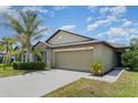 Charming one-story home featuring a well-maintained lawn and a spacious two-car garage at 10104 Carloway Hills Dr, Wimauma, FL 33598
