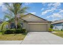 Charming one-story home featuring a well-maintained lawn and a spacious two-car garage at 10104 Carloway Hills Dr, Wimauma, FL 33598