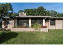 Exterior view of house with flower bed and screened porch at 10818 Land O Lakes Blvd, Land O Lakes, FL 34638