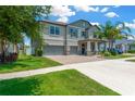 Beautiful two-story home with a well-maintained lawn, brick driveway, and a two-car garage at 11612 Sunburst Marble Rd, Riverview, FL 33579