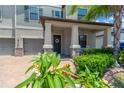 Inviting front porch with decorative columns, a wreath on the front door, and lush landscaping at 11612 Sunburst Marble Rd, Riverview, FL 33579