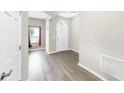 Bright foyer boasts wood floors, a window with red accents, and a white front door at 11623 Tetrafin Dr, Riverview, FL 33579