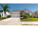 Inviting one-story home features a two-car garage, lush landscaping, and a stone-accented entrance at 11623 Tetrafin Dr, Riverview, FL 33579