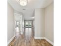 Bright hallway featuring wood-look flooring and views of a sunlit living area with access to the backyard at 1175 San Carlos Ne Ave, St Petersburg, FL 33702