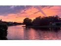 Scenic water view at sunset, with a tree-lined bank in the foreground and colorful sky reflected on the water at 1175 San Carlos Ne Ave, St Petersburg, FL 33702