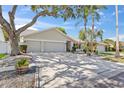 Well-maintained single-story home featuring a three-car garage and mature trees at 11927 Steppingstone Blvd, Tampa, FL 33635