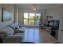 Bright living room featuring hardwood floors, comfortable sofa, large window with views, and a modern desk at 1216 S Missouri Ave # 223, Clearwater, FL 33756