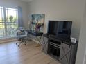Comfortable living area featuring hardwood floors, a writing desk with decor, and TV on storage cabinet at 1216 S Missouri Ave # 223, Clearwater, FL 33756