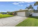 Well-maintained home featuring a spacious driveway, a two-car garage, and lush green lawn at 13000 90Th Ave, Seminole, FL 33776