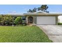 Charming single-story home with an attached two-car garage, and a lush green lawn at 13000 90Th Ave, Seminole, FL 33776