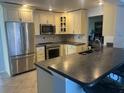 This kitchen features granite countertops, stainless steel appliances, and tile flooring at 13000 90Th Ave, Seminole, FL 33776