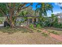 Charming single-story home with lush landscaping and a welcoming brick pathway at 1402 E Mohawk Ave, Tampa, FL 33604