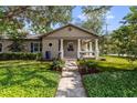 Inviting home with a stone walkway, manicured landscaping, and a cozy front porch at 213 N Hesperides St, Tampa, FL 33609