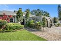 Landscaped walkway leading to a lovely home with a charming arched entryway and well-maintained lawn at 2134 Serpentine S Cir, St Petersburg, FL 33712