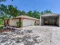 View of garage with white door and additional metal storage building at 2217 High Point Dr, Brandon, FL 33511