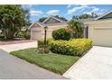 Inviting villa featuring a well-manicured lawn and vibrant flowerbeds at 2403 Nantucket Field Way # 27, Sun City Center, FL 33573