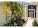 Welcoming front entry featuring a screen door and lush tropical plants at 2403 Nantucket Field Way # 27, Sun City Center, FL 33573