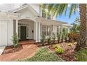 Inviting front porch with brick walkway, lush landscaping, and white columns providing curb appeal at 2403 W Sunset Dr, Tampa, FL 33629