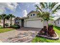 Well-maintained home with landscaped front yard, brick driveway, and two-car garage at 2456 Arbor Wind Dr, Lutz, FL 33558