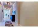 Bright hallway with light tile flooring, modern light fixtures, and neutral wall colors at 2456 Arbor Wind Dr, Lutz, FL 33558