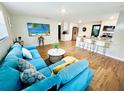 Bright, open-concept living room featuring wood floors, a sectional sofa, and adjacent kitchen at 2606 E 97Th Ave, Tampa, FL 33612