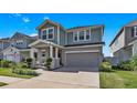 Inviting two-story home with a well-maintained lawn and garden, a covered porch, and attached two-car garage at 28809 S Orange Berry S Dr, Wesley Chapel, FL 33543