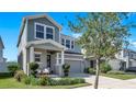Beautiful two-story home with a covered front porch, attached two-car garage, and lush landscaping at 28809 S Orange Berry S Dr, Wesley Chapel, FL 33543