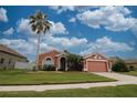Landscaped single-story home featuring a manicured lawn and two-car garage at 29650 Eagle Station Dr, Wesley Chapel, FL 33543