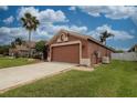 Side view of a single-story home showing the two-car garage and grassy front yard at 29650 Eagle Station Dr, Wesley Chapel, FL 33543