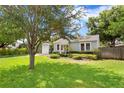 Well-maintained home exterior with lush green lawn and mature shade tree at 3404 W Leona St, Tampa, FL 33629