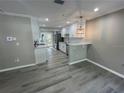 Modern kitchen featuring white cabinets, stainless steel appliances, and trendy gray wood-look flooring at 3718 N 36Th St, Tampa, FL 33610